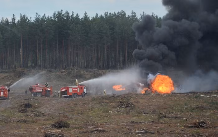 Vượt qua khu vực địa hình phức tạp các xe chữa cháy đã tiếp cận được chiếc máy bay đang bị bốc cháy và xả vùi phun bọt khí vào đám cháy.