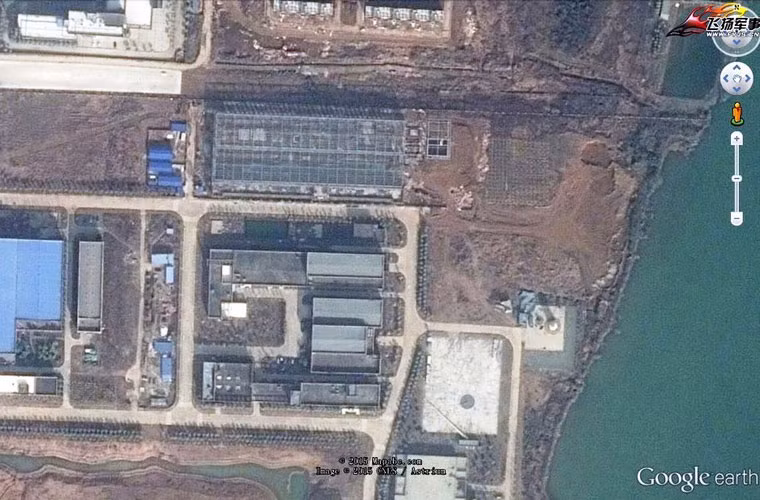 Quanh đó là những kiến trúc nhà cửa cỡ lớn, có thể là khu vực nhà xưởng.