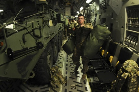 Một binh sĩ đang vác hành lý ra khỏi máy bay.