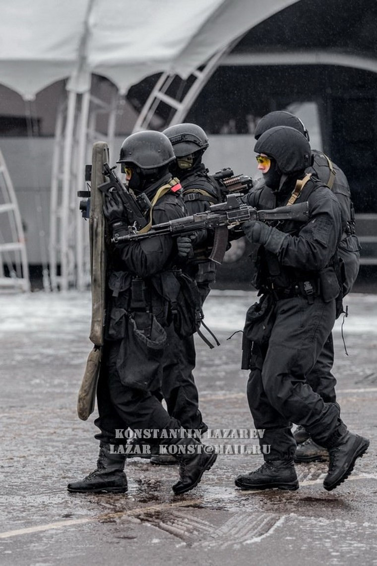 Những người lính di chuyển cẩn thận, ép sát về sau phía bia đỡ đạn.