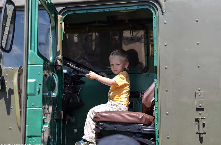 Không chỉ người lớn háo hức được trải nghiệm cùng xe phóng tên lửa chiến lược này, mà các em bí cũng được trao cơ hội này. Trong ảnh là một bé trái ngồi trong buồng lái của xe phóng tên lửa chiến lược mạnh nhất của quân đội Nga.