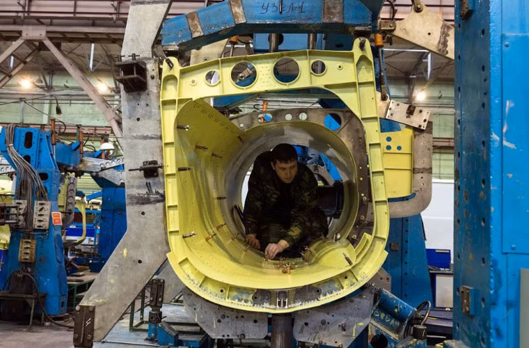 Một công nhân đang làm trong bộ phận cửa hút không khí động cơ phản lực trên Su-34.