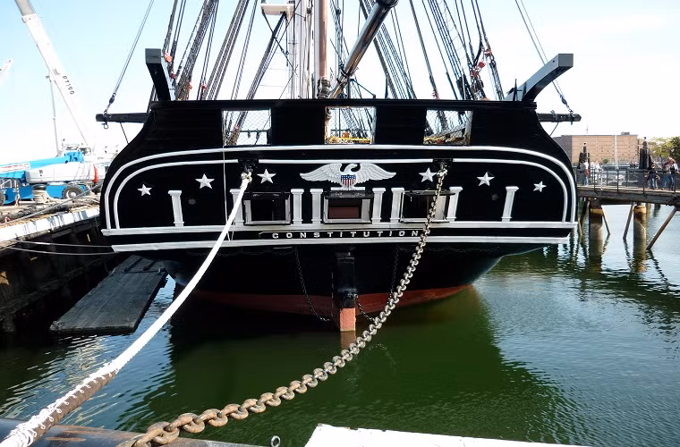 Theo thiết kế, USS Constitution được đóng hoàn toàn bằng gỗ với 3 cột buồm chính, lượng giãn nước tối đa là 2.200 tấn và có thể di chuyển với vận tốc tối đa là 13 hải lý/giờ. Trong ảnh là đuôi tàu của USS Constitution với biểu tượng đại bàng trắng được giữ nguyên kể từ năm 1797 cho tới nay.