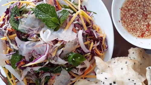 Nộm xoài sứa thanh mát, rất hợp với thời tiết nóng bức Ngày Gia đình Việt Nam năm nay. Vị ngọt mát của sứa cũng giúp mâm cơm gia đình đa dạng hơn với nguyên liệu là hải sản. Để làm món ngon này, bạn cần chuẩn bị sứa, xoài xanh, hành tây, dưa leo, bắp cải tím, tắc, ớt, rau trộn gỏi, tỏi, nước mắm, đường và lạc.