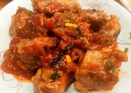 Đun nóng chảo dầu vừa đủ ngập sườn, chiên lửa nhỏ đến khi sườn có màu vàng nâu. Phi thơm hành tỏi, xào cà chua mềm nhuyễn thì cho sườn, gia vị vào. Rim sườn đến khi nước xốt sệt thì tắt bếp, rắc chút hành lá, tiêu là có thể thưởng thức.