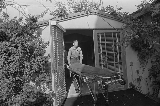 Người ta phủ một tấm chăn mỏng lên thi hài Marilyn khi di chuyển từ nhà riêng của cô đến cơ sở pháp y.