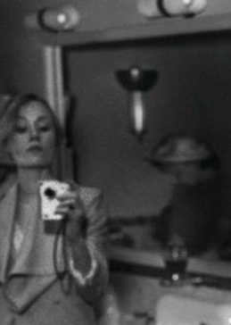 Nguyên do là vì người phụ nữ xuất hiện phía sau Marilyn Monroe có hành động lạ. Một số người suy đoán người phụ nữ này đang cầm trên tay một thiết bị nhỏ và giơ tay lên giống như để chụp ảnh bằng smartphone thời nay.