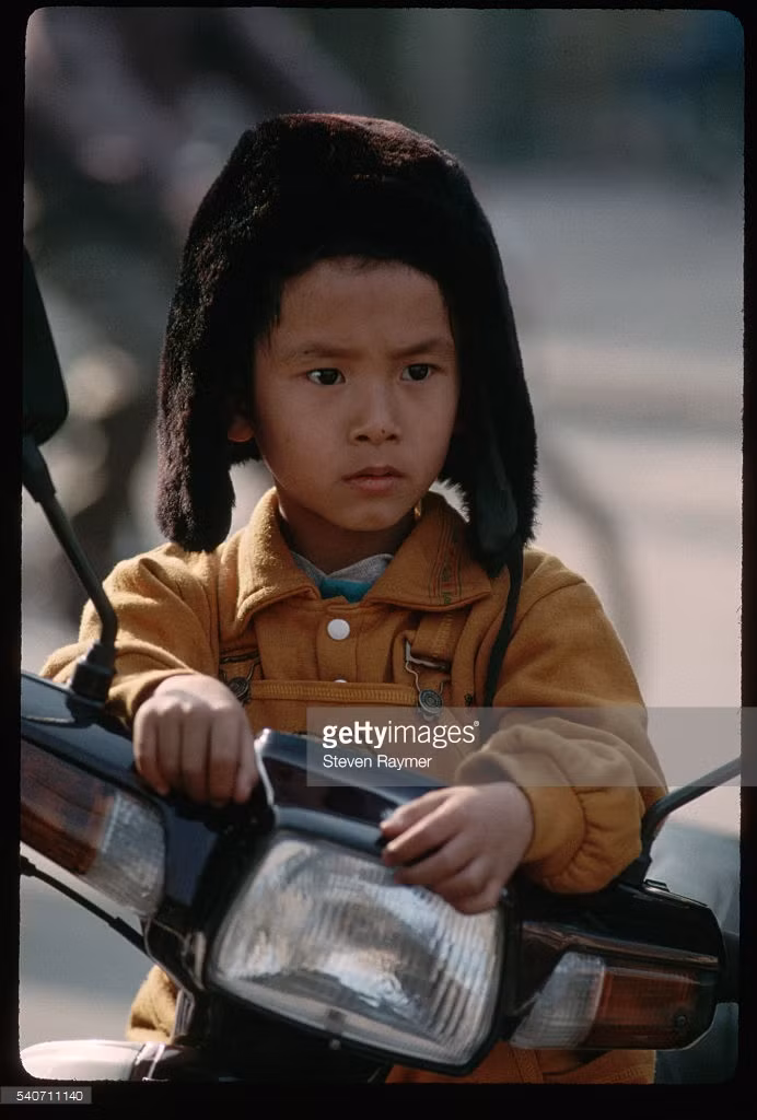 Em bé ngồi chờ bố mẹ đi lễ trong đền Ngọc Sơn.