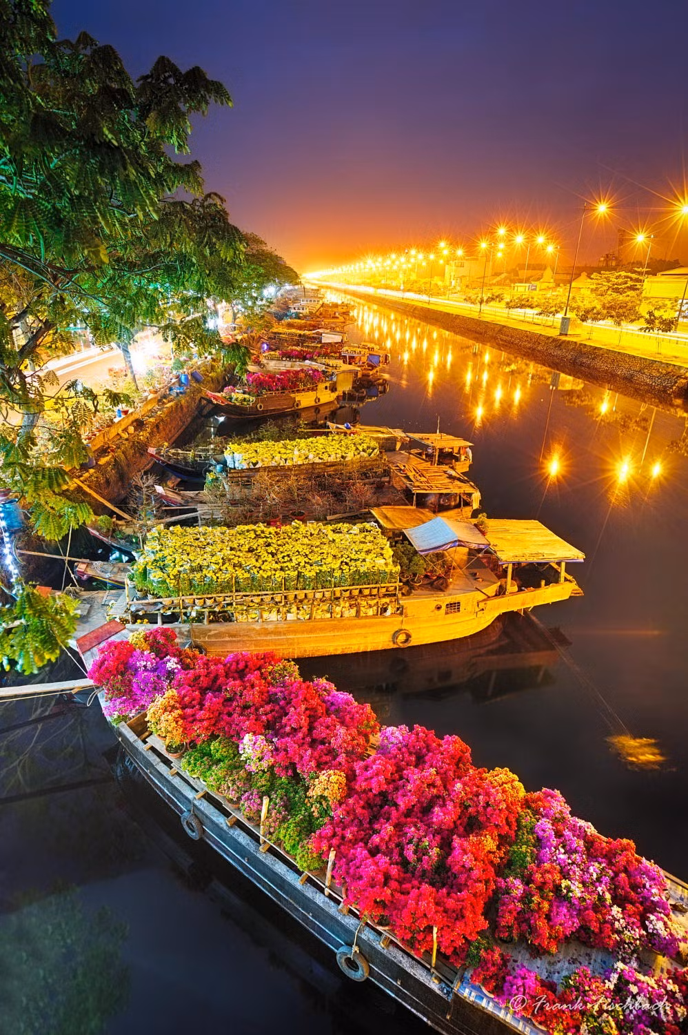 Những con thuyền chở hoa Tết neo đậu trên rạch Bến Nghé, TP HCM. Ảnh: Frank Fischbach - 500px.com