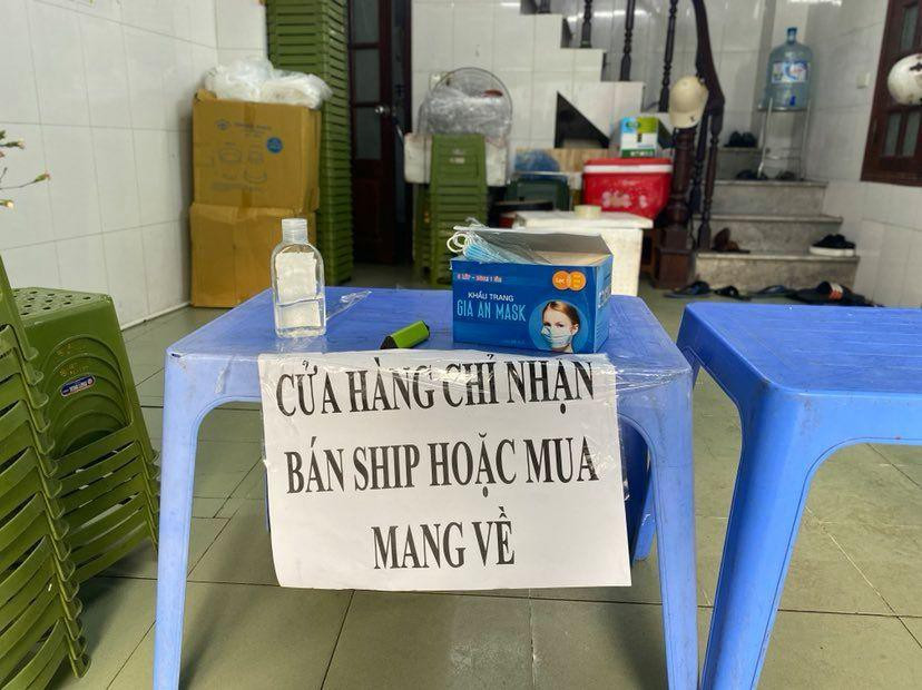Một quán trên phố Quang Trung chỉ bán mang đi, dừng phục vụ tại chỗ dù có không gian trong nhà rộng rãi. Quán tặng miễn phí khẩu trang, có nước rửa tay cho khách tới mua, nhân viên giao hàng