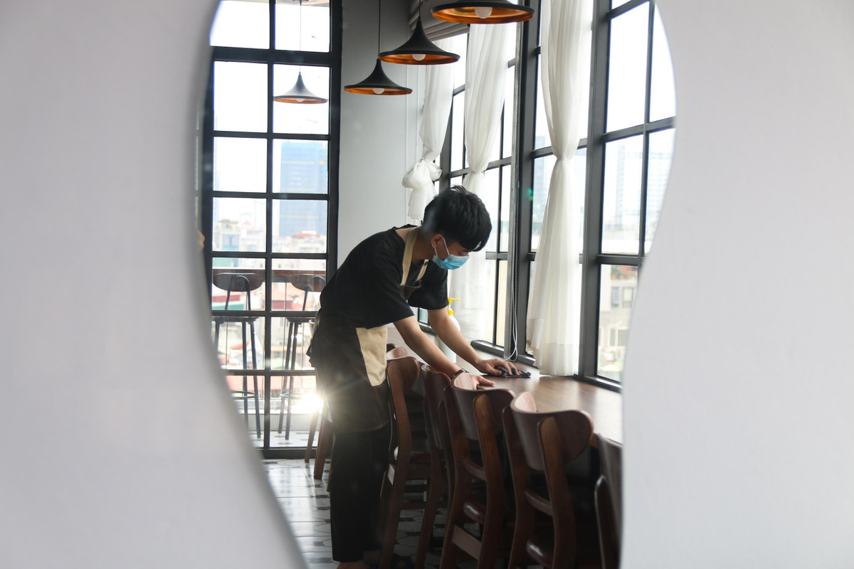 Một quán cà phê khác trên phố Thái Hà chỉ hoạt động tầng một, cất bớt bàn ghế, nhận không quá 5 khách cùng lúc. Chị Phạm Khánh Huyền (quản lý quán cafe) cho biết, thói quen của khách hàng có sự thay đổi đáng kể tuần qua. Cụ thể, đơn trên ứng dụng giao nhận tăng vọt, còn bán trực tiếp thì giảm trông thấy. Nhân viên quán thường xuyên lau dọn vệ sinh, đảm bảo công tác phòng dịch đón khách ăn uống tại chỗ