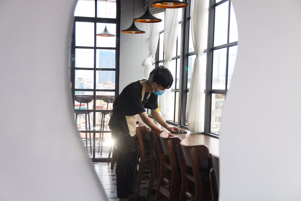 Một quán cà phê khác trên phố Thái Hà chỉ hoạt động tầng một, cất bớt bàn ghế, nhận không quá 5 khách cùng lúc. Chị Phạm Khánh Huyền (quản lý quán cafe) cho biết, thói quen của khách hàng có sự thay đổi đáng kể tuần qua. Cụ thể, đơn trên ứng dụng giao nhận tăng vọt, còn bán trực tiếp thì giảm trông thấy. Nhân viên quán thường xuyên lau dọn vệ sinh, đảm bảo công tác phòng dịch đón khách ăn uống tại chỗ