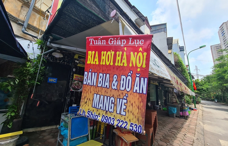 Tấm biển thông báo ban bia và đồ ăn mang về được đặt phía trước một nhà hàng trên phố Trương Định để khách dễ dàng quan sát.