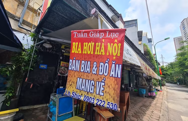 Tấm biển thông báo ban bia và đồ ăn mang về được đặt phía trước một nhà hàng trên phố Trương Định để khách dễ dàng quan sát.