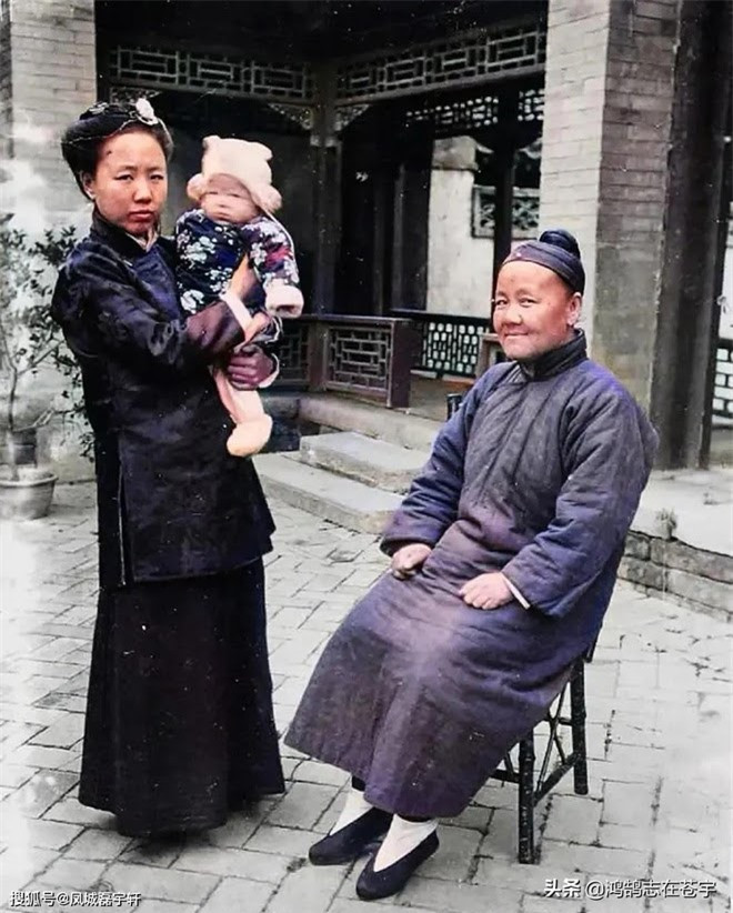 Một bức ảnh cũ chụp 3 thế hệ trong một nhà được phục chế màu. Người bố chồng ngồi trên ghế trúc vẻ mặt kiêu căng, đưa ánh mắt đầy khinh thường về phía máy ảnh. Người con dâu còn trẻ ôm đứa cháu đứng bên cạnh. Sân nhà của họ rất rộng, hành lang được chạm khắc gỗ tinh xảo, dùng gạch lát nền ngoài sân, vừa nhìn là biết nhà giàu.