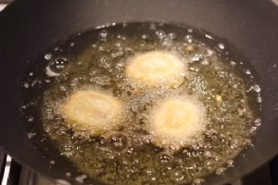 Tiếp đó thả viên bò khoai tây vào chiên chín vàng giòn trên chảo dầu sôi.