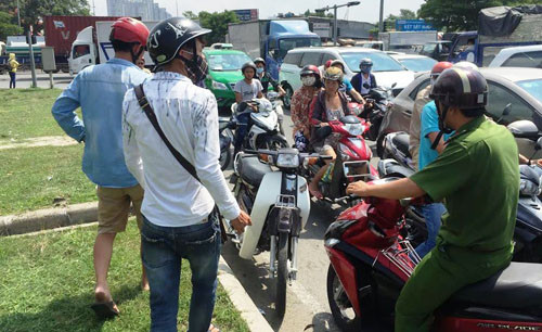 Anh Th. (áo trắng) đang bàn giao chiếc xe máy hiệu Dream của đối tượng cho Công an phường Tân Phong, quận 7.