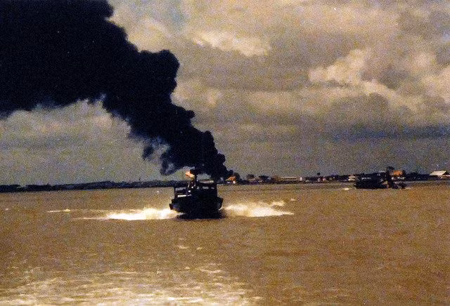 Kho xăng Nhà Bè cháy liên tục trong 12 ngày đêm trước khi ngọn lửa được dập tắt hoàn toàn. Ảnh: cột khói bốc lên ở kho xăng Nhà Bè nhìn từ phía sông Soài Rạp. Nguồn ảnh: Pinterest.