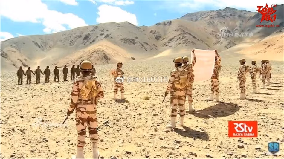 Hai lực lượng quân đội Ấn Độ và Trung Quốc dàn hàng ngang đứng ở hai bên biên giới, phía Ấn Độ có giơ cao biểu ngữ. Phía Trung Quốc thậm chí còn không mang theo vũ khí. Nguồn ảnh: RStv.