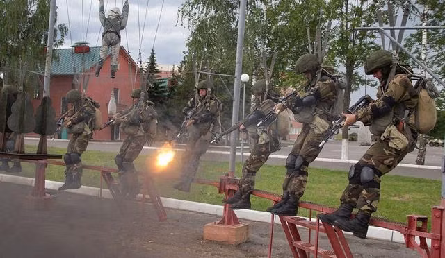 Lính dù Belarus còn có một bài tập khác cực kỳ lạ đó là bắn súng khi còn bị treo lủng lẳng trên không. Khác với các lực lượng dù của Mỹ hay Trung Quốc, lính dù Belarus sẵn sàng rút súng ra chiến đấu ngay từ khi họ còn chưa chạm đất. Nguồn ảnh: Sina.