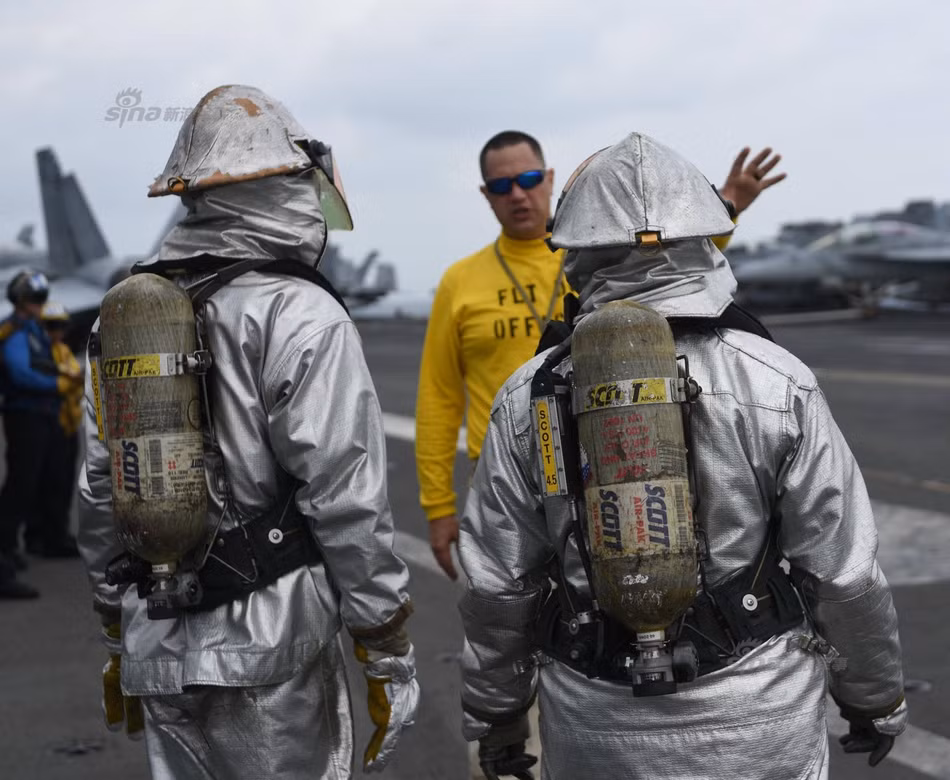 Đội cứu hỏa trên tàu với trang phục cách nhiệt. Do tàu sân bay được làm hoàn toàn từ kim loại nên sẽ dẫn nhiệt rất nhanh, đòi hỏi thủy thủ đoàn phải có các kỹ năng chữa cháy khác hoàn toàn so với cứu hỏa kiểu bình thường trên đất liền. Nguồn ảnh: USNavy.