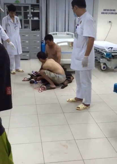 Tại bệnh viện một người bị ốm đi truyền nước xúc động khi chứng kiến cảnh nam thanh niên ngồi xuống cầu cứu bác sĩ cứu chó Doberman của anh.