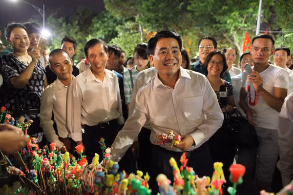 Ông Chung vui vẻ trò chuyện với người dân và mua nhiều tò he làm kỉ niệm.