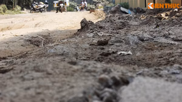 Mặt đường nham nhở đầy bùn đất khô.