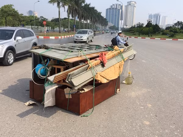 Chiếc xe ba gác chở hàng cồng kềnh va chạm với xe đạp điện bị lật.