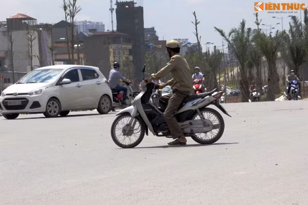 Người đàn ông run sợ, di chuyển chậm và phải chống một chân xuống đường khi đi qua nút giao thông Bưởi - Hoàng Hoa Thám - Lạc Long Quân.