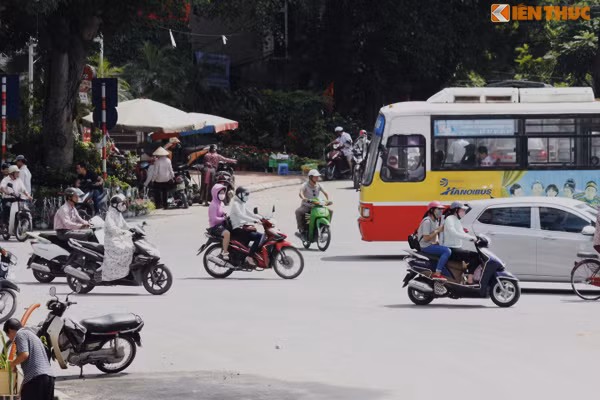 Chiếc xe máy (xanh) di chuyển từ hướng đường Hoàng Hoa Thám lao nhanh qua đầu xe bus.