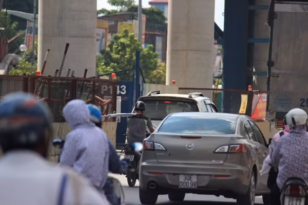 Mặc dù một tay giữ, vác vật liệu xây dựng trên vai, tay còn lại điều khiển xe máy vô cùng nguy hiểm nhưng nam thanh niên vẫn chạy bon bon trên đường Hà Nội.