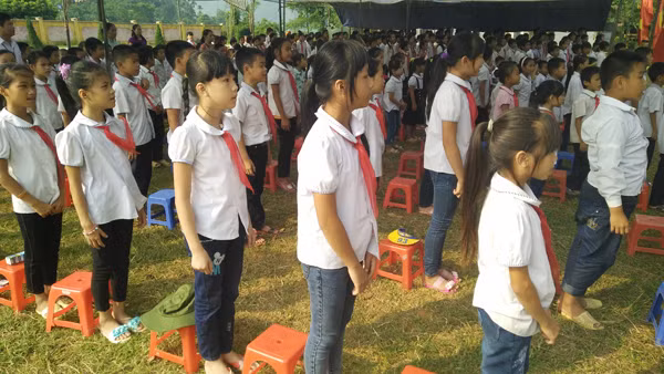 Các em học sinh đứng trang nghiêm trong tiết mục chào cờ.