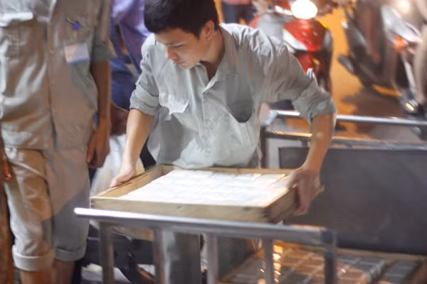 Trong khi đó, nhân viên của cơ sở bánh Trung thu Bảo Phương liên tục vận chuyển những chiếc bánh mới, nóng hổi ra lò để kịp thời bán cho mọi người đang tập trung nhau xếp hàng chờ mua.