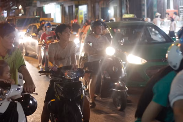 Nhiều ô tô, xe máy di chuyển qua cơ sở bánh Bảo Phương phải đi chậm, thỉnh thoảng xảy ra ùn tắc do cảnh tượng xe máy dừng lại cơ sở mua bánh hỗn loạn.