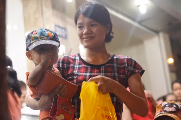 Có rất nhiều ông bố, bà mẹ bồng bế cả con đến xếp hàng giữa đêm để mua cho bằng được bánh Trung thu Bảo Phương.