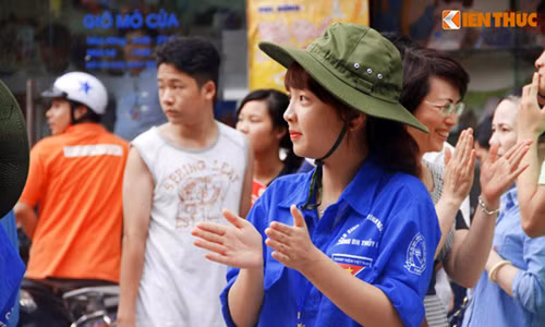 Nữ tình nguyện viên có khuôn mặt khả ái vỗ tay chia sẻ niềm vui cùng thí sinh sau khi ra khỏi phòng thi tại cụm thi trường ĐH Thủy Lợi, Hà Nội.