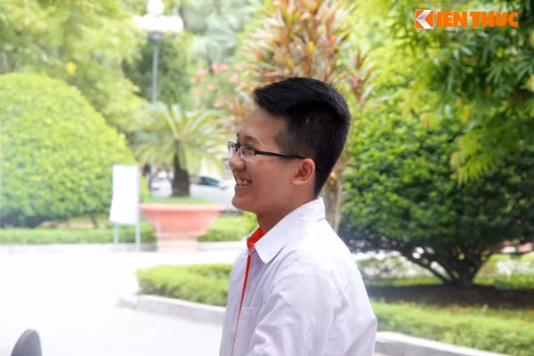 Nam sinh nở nụ cười rất tươi, ưng ý với bài làm của mình.