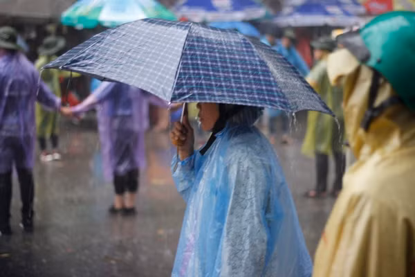 Dù mưa lớn nhưng phụ huynh vẫn kiên nhẫn đội mưa chờ con ngoài phòng thi.