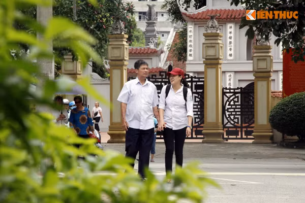 Phụ huynh nắm chặt tay cô con gái động viên con sau khi kết thúc bài làm môn Địa lý. Ảnh: Hưng Bùi.