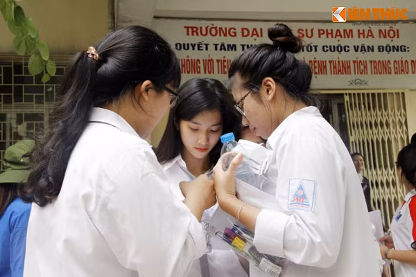 Nữ sinh xinh xắn đang cùng nhóm bạn nán lại sân trường để cùng nhau chia sẻ bài làm.