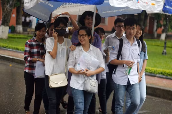 Đúng 16h15, các thí sinh tham dự môn thi Vật lý tại cụm thi trường Đại học Thủy Lợi (Hà Nội) được các tình nguyện viên che ô đón từ trong phòng thi ra đến chỗ phụ huynh đang chờ.