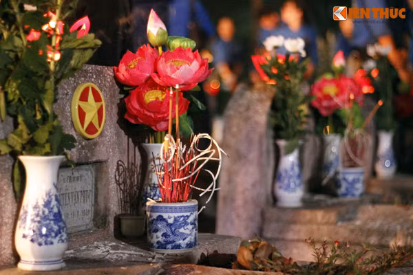 Sau khi làm xong các thủ tục dâng hương, những ngọn nến lung linh được thắp lên phần mộ các liệt sỹ.