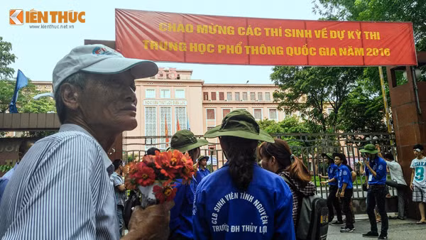 Ông Đức kiên nhẫn chờ, cầm bó hoa tươi thắm trên tay đợi cháu ngoại làm bài.