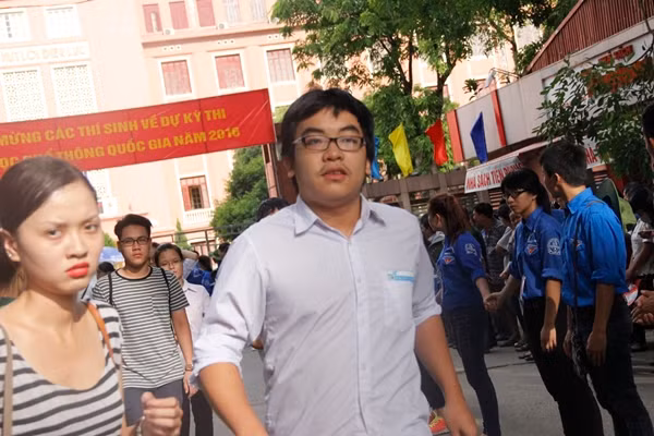 Em Nguyễn Việt Anh (nam) chạy thật nhanh ra chỗ người thân đang đứng chờ để chia sẻ cảm xúc vì em hoàn thành tốt bài thi của mình. "Em học chuyên Ngoại ngữ, song thấy đề đưa ra cũng không quá khó các bạn có học lực trung bình làm bài vẫn có thể qua được điểm trung bình". Ảnh: Mạnh Hưng.