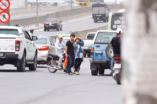 Người đi bộ đánh cược tính mạng, bất chấp nguy hiểm sang đường sau khi bước xuống khỏi xe khách từ trên đường cao tốc trên cao.