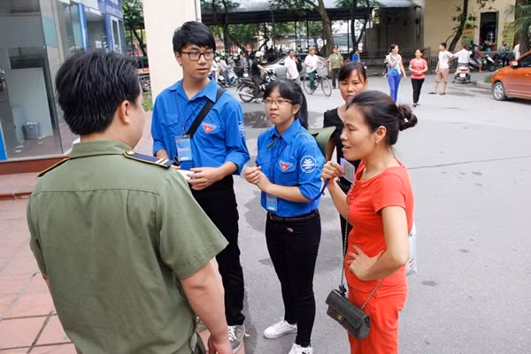 Người nhà (áo đỏ) lo lắng khi con quên mang giấy tờ thi (thẻ dự thi, CMTND) Ảnh: Hưng Bùi.