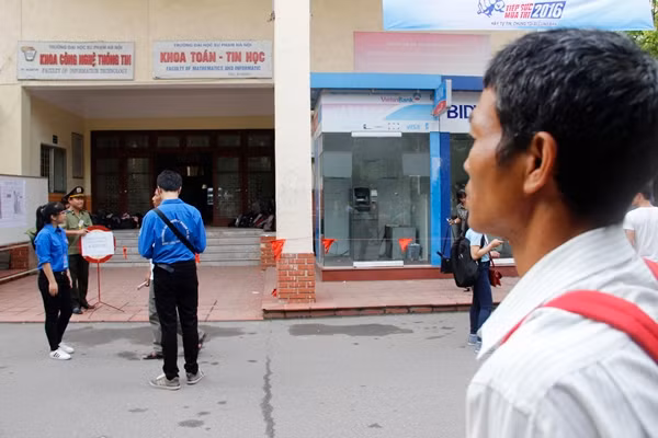 Đúng 7h, các thí sinh tại cụm thi trường ĐH Sư phạm đã vào bên trong phòng thi, phụ huynh đứng bên ngoài chờ đợi cũng không kém phần lo lắng. Ảnh: Hưng Bùi.