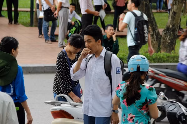 Do phải dậy sớm đến điểm thi, nhiều thí sinh chưa kịp ăn sáng đã được phụ huynh mua cho chiếc bánh mỳ, hộp sữa để lấy sức "vượt vũ môn". Ảnh: Hưng Bùi.