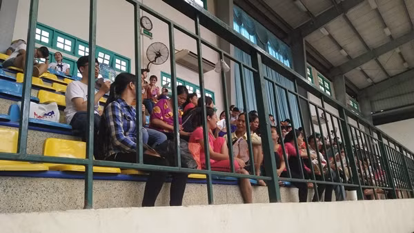 Các bậc phụ huynh tập trung ngồi trên ghế chờ tại phòng tập thể dục, thể thao trường ĐH Sư phạm rất đông.